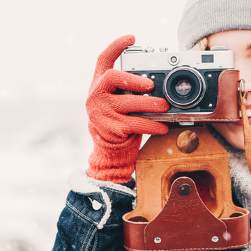 Jeune femme chaudement vêtue tenant un appareil photo