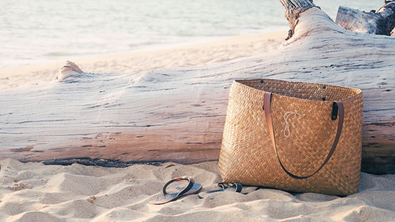 Tasche und Sandalen am Strand