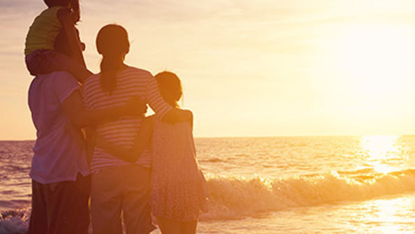 Familie bei Sonnenuntergang am Meer