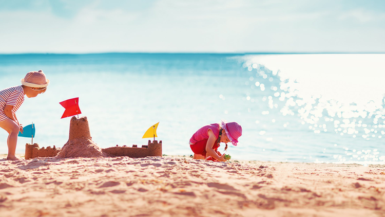 Kinder spielen am Strand