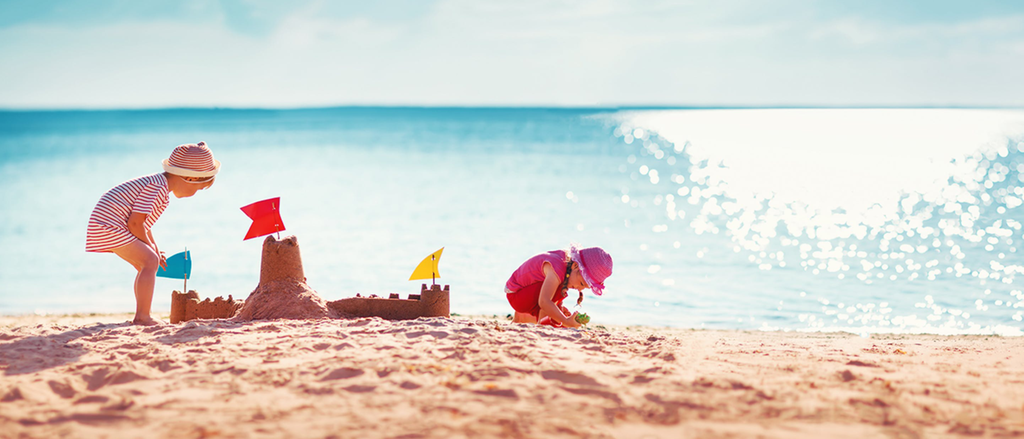 Kinder spielen am Strand