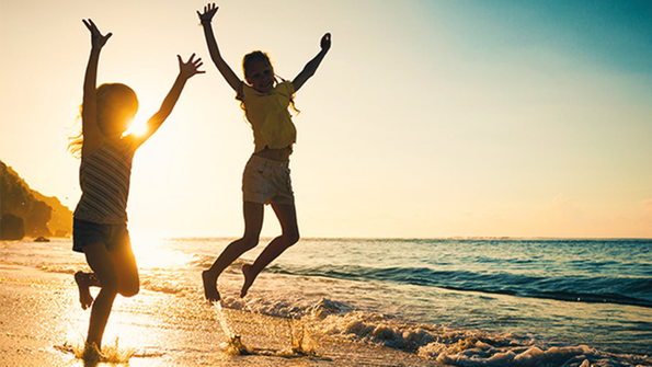 Kinder bei Sonnenuntergang am Meer