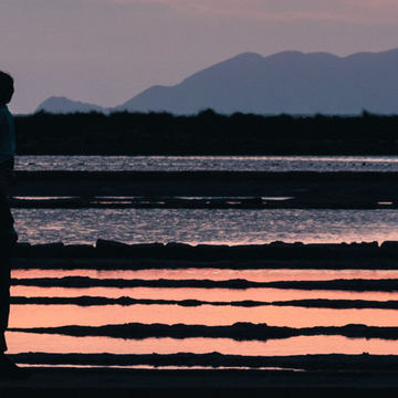 Un homme et son enfant devant les marais salants à Trapani