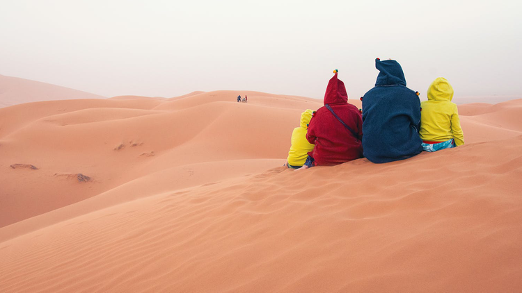 Familie auf einer Sanddüne in Marokko
