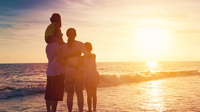 Familie bei Sonnenuntergang am Meer