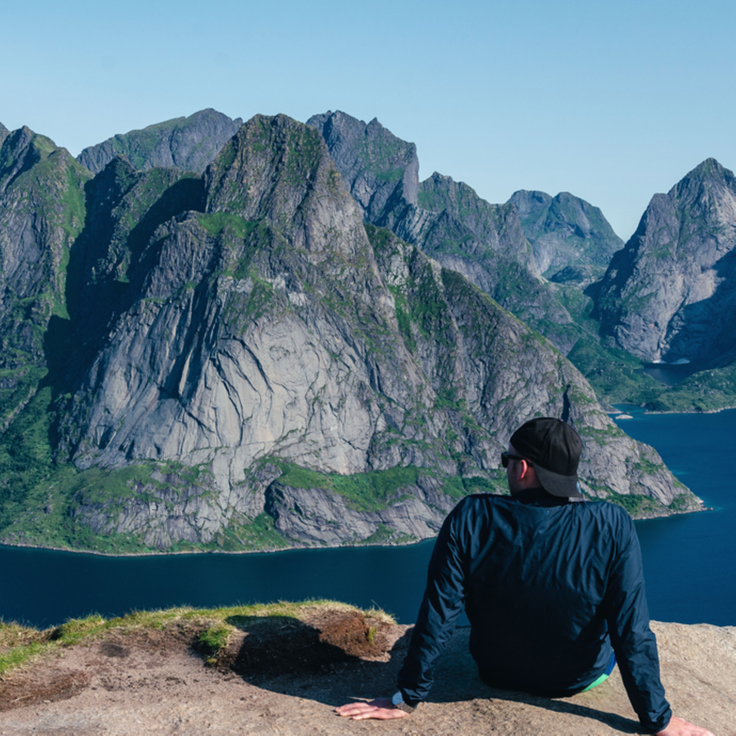 Junger Mann genießt die Aussicht auf die Fjorde der Lofoten