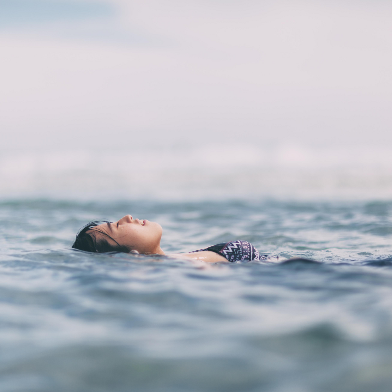 Eine Frau lässt ihren Körper auf der Wasseroberfläche treiben
