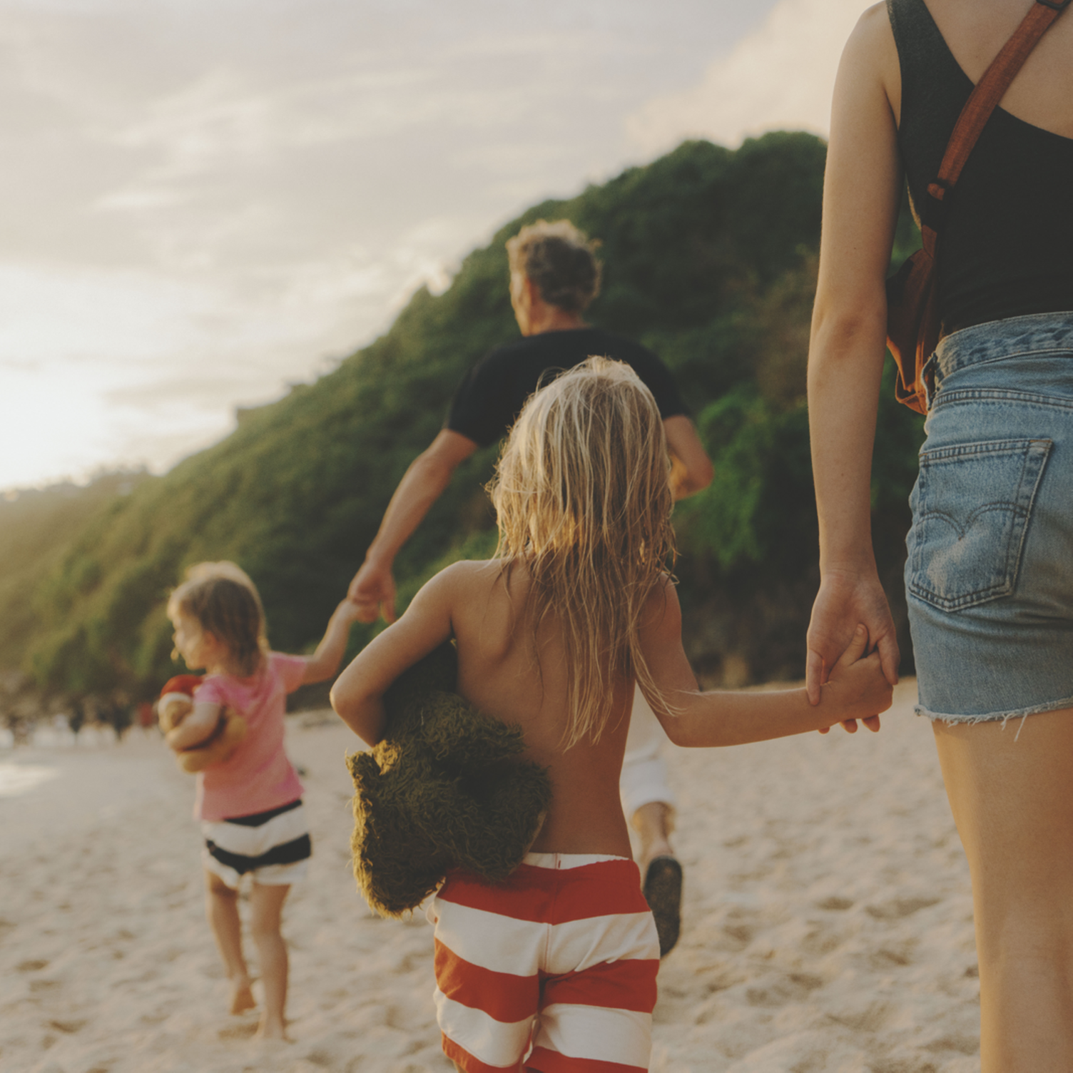 Parents et enfants se promenant sur la plage à Bali