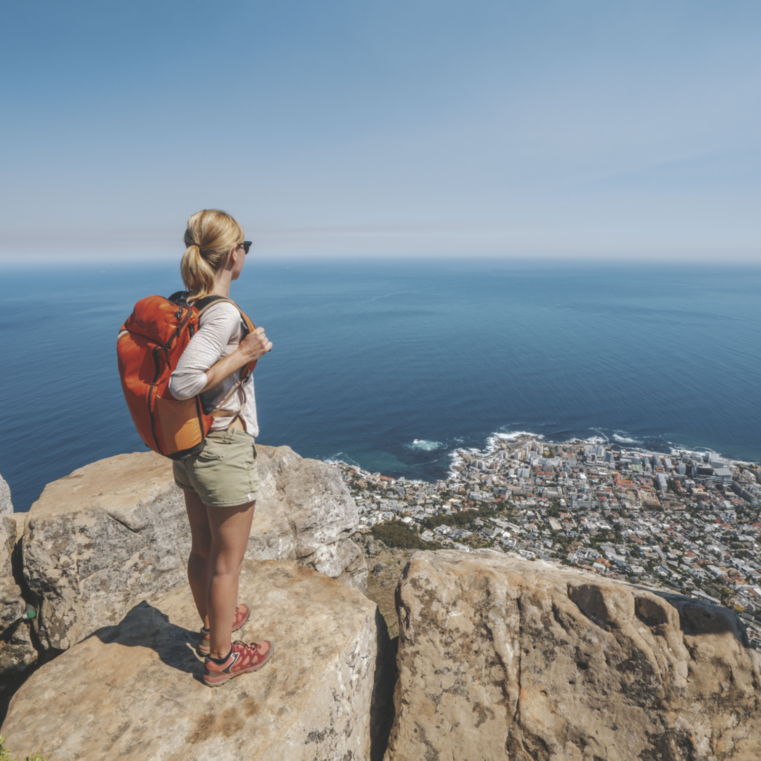 Jeune femme debout sur un rocher à Lion’s Head surplombant la ville du Cap en Afrique du Sud