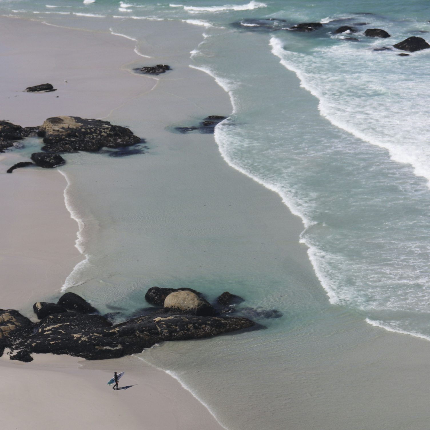 Un surfeur sur une plage de la péninsule du Cap en Afrique du Sud