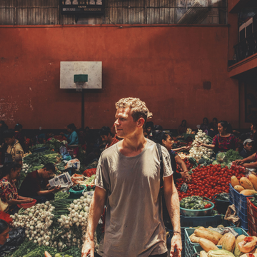 Un voyageur au milieu d’un marché de fruits et légumes en Asie