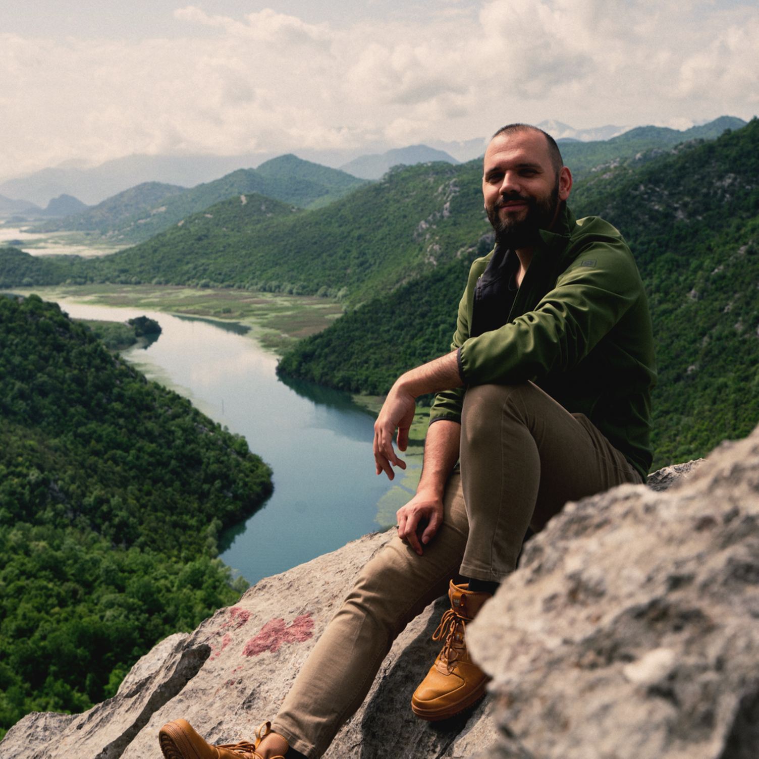 Nikola, agente local de Evaneos en Montenegro, sentado frente a un río y un paisaje montañoso