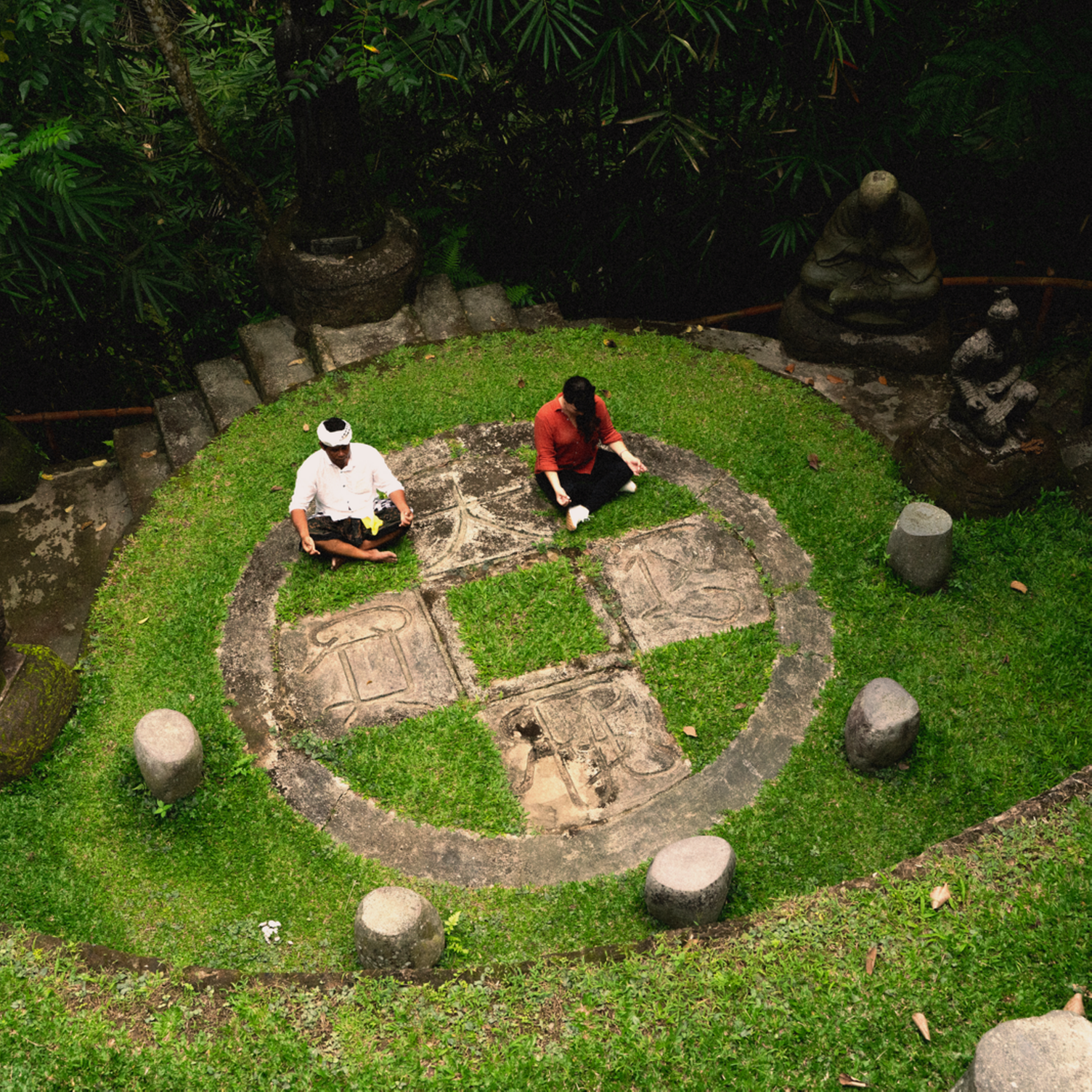 Un hombre y una mujer meditan en un jardín de Bali
