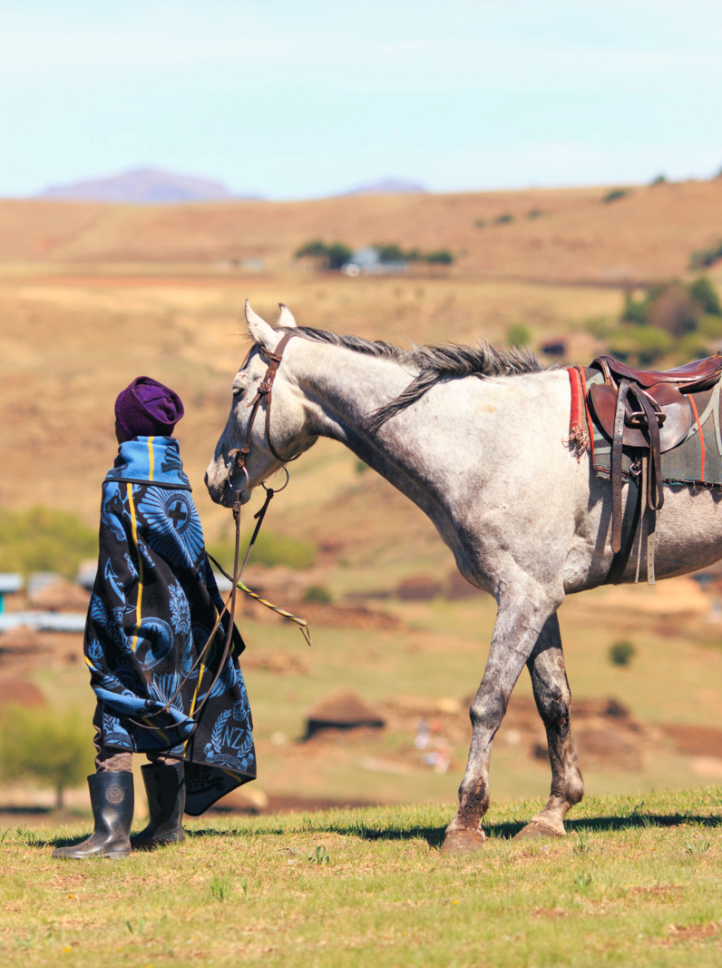 Unidentified basotho man with his horse wearing traditional blanket - Lesotho