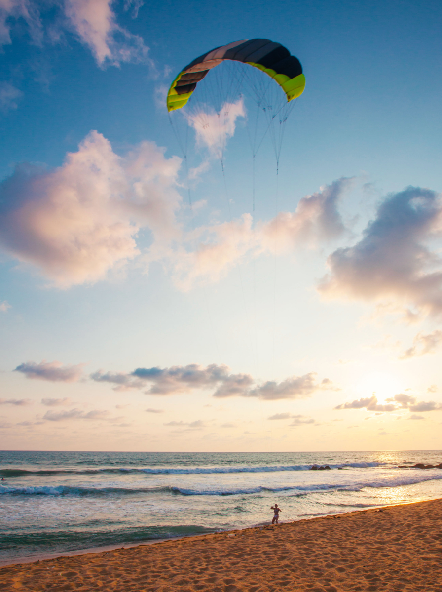 Young woman flying a kite at the seabeach in Sri Lanka