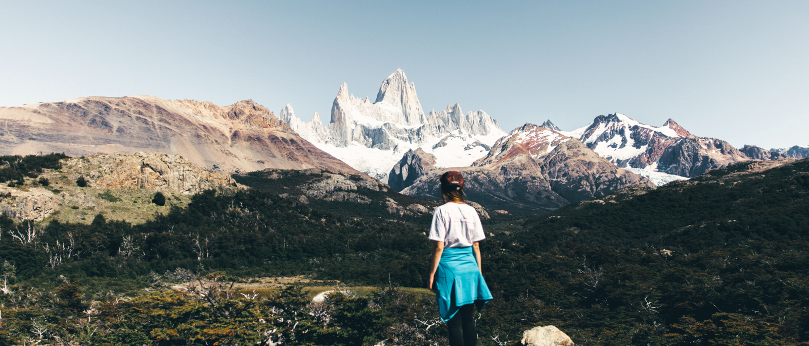 Woman in cap and white t-shirt enjoying the trip at Argentinian Patagonia and looking at beautiful Fitz Roy mountain near El Chalten