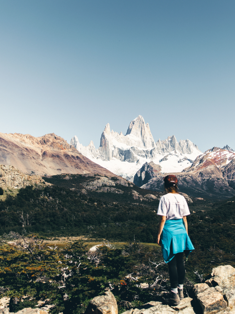 Woman in cap and white t-shirt enjoying the trip at Argentinian Patagonia and looking at beautiful Fitz Roy mountain near El Chalten