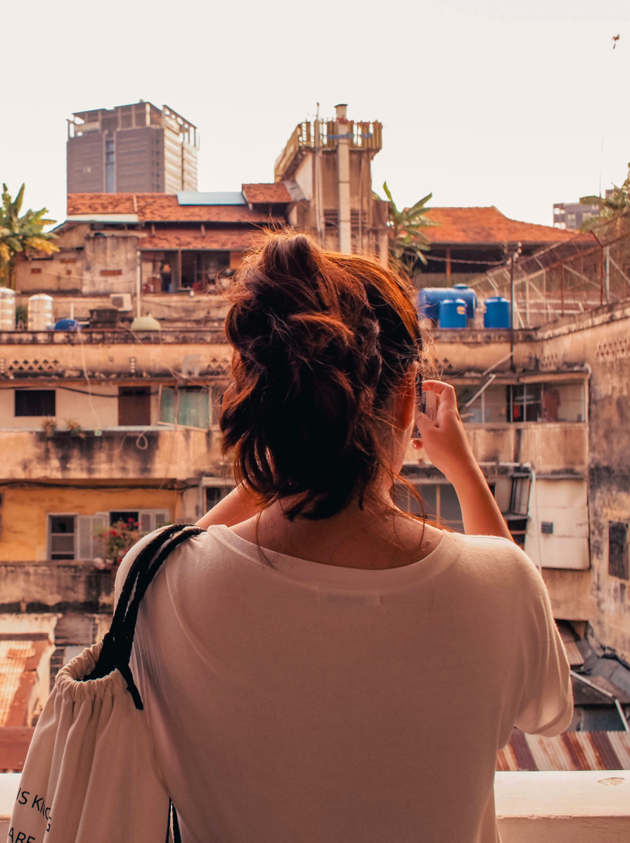 A girl taking a picture of old buildings in Ho chi Minh City, Vietnam
