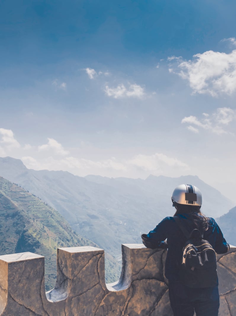 Traveler woman standing on the top of mountain at stopover for sightseeing during the tourist route of North Vietnam.Beautiful landscape for adventure travel