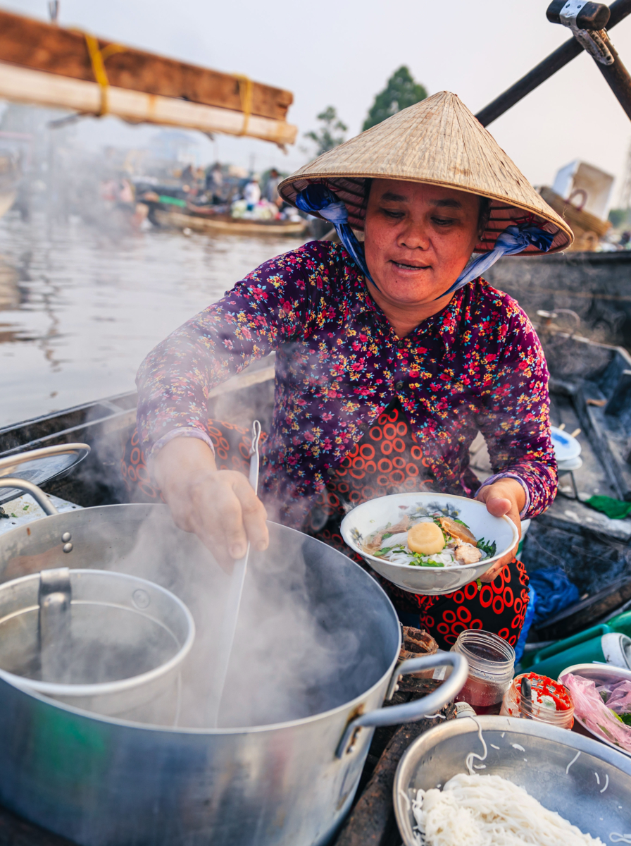 Femme vietnamienne vendant la fameuse soupe de nouilles, marché flottant, Delta du Mékong, Vietnam