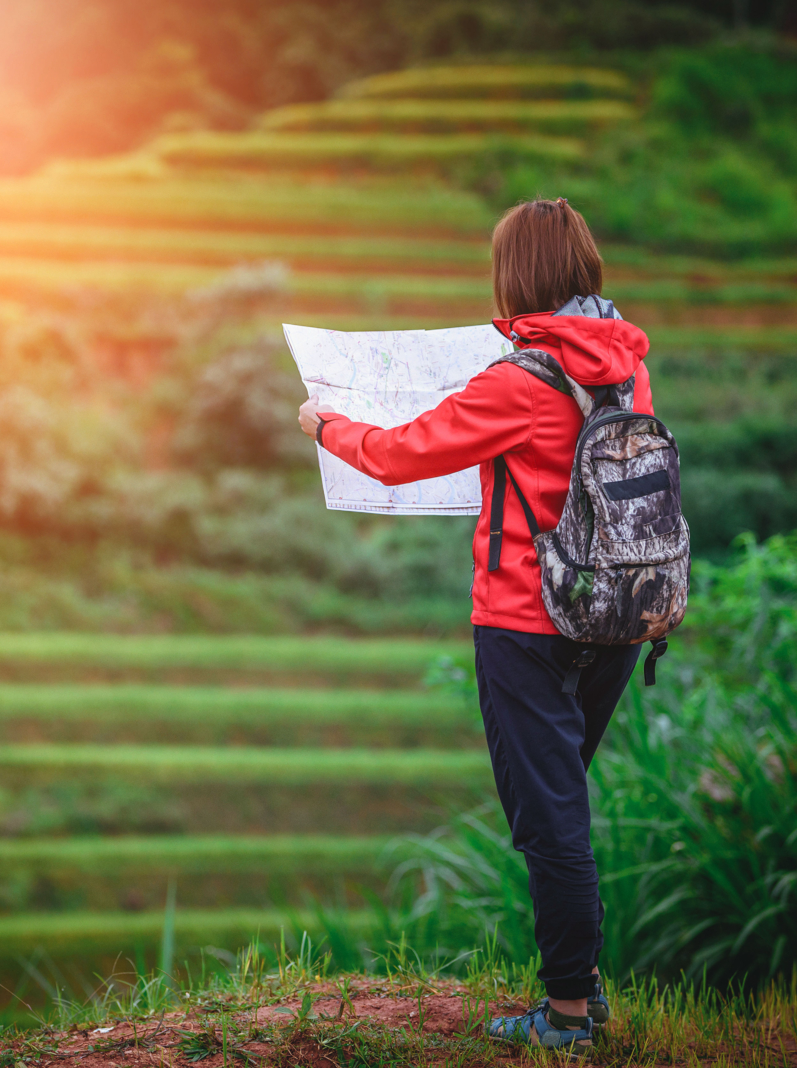 Young women backpacker looking to the map on rice fields terraced in Mu Cang Chai, YenBai, Vietnam