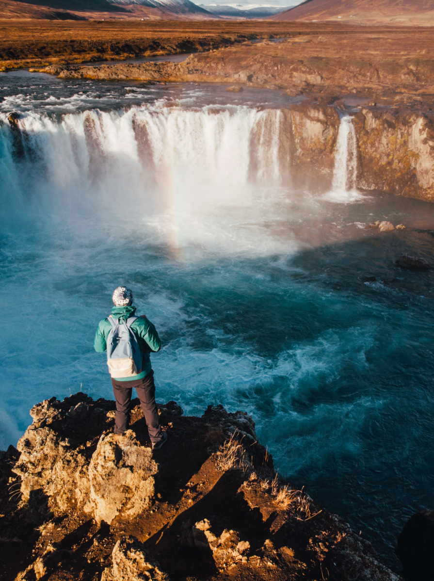 Man looking at scenic view of waterfall in Iceland