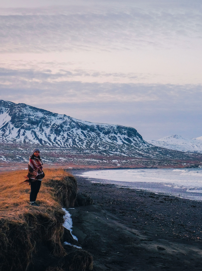 A girl standing in the beach area of snaefellsjokull national park