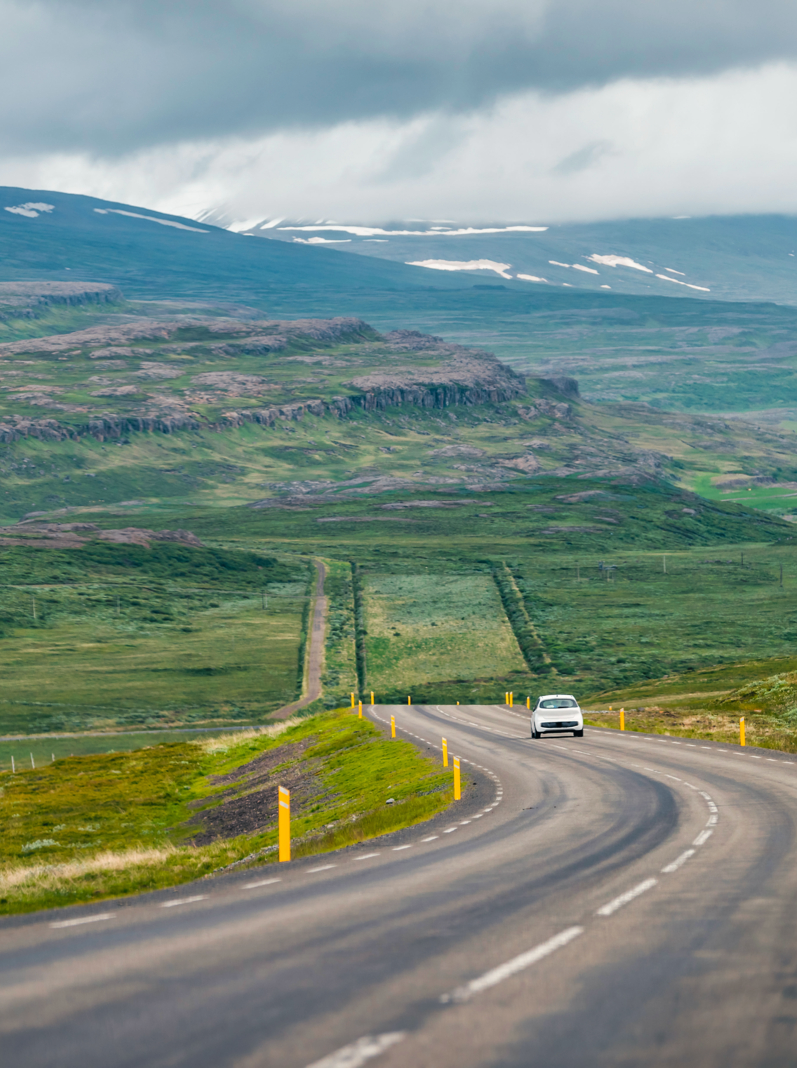 Rocade est Islande highlands Highway paysage vert nu aride et voiture sur pente raide avec couvert nuageux orageux près de Egilsstadir