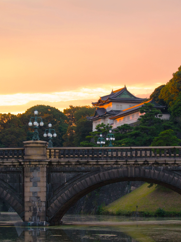Nijubashi over the Nijubahi-bori at sunset, Kokyogaien National Gardens , Imperial Palace Tokyo. One of Japan's most well known bridges. with Palace in background.
