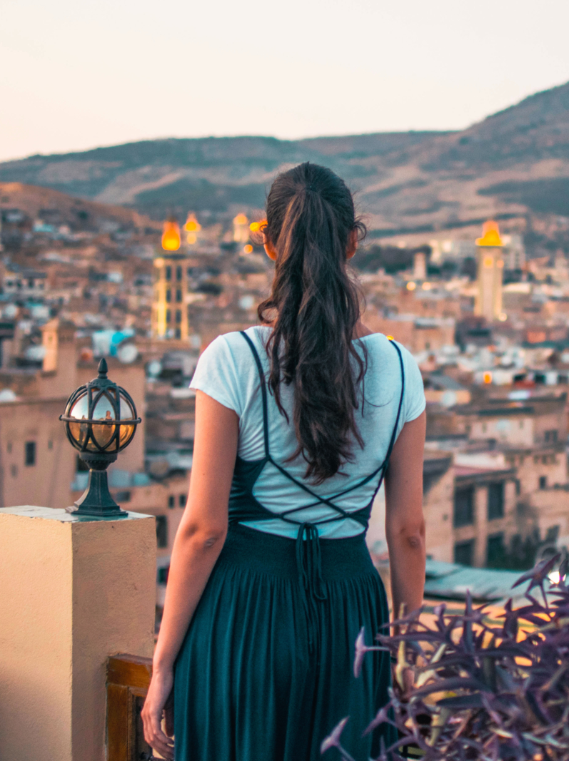 Girl with dark long hair overlooking a medina in city Fes, Morocco