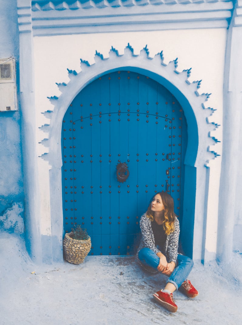 Young Caucasian woman sitting near the doors in Chefchaouen