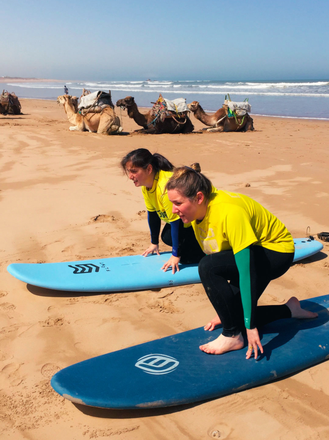two girls practicing surf on the beach