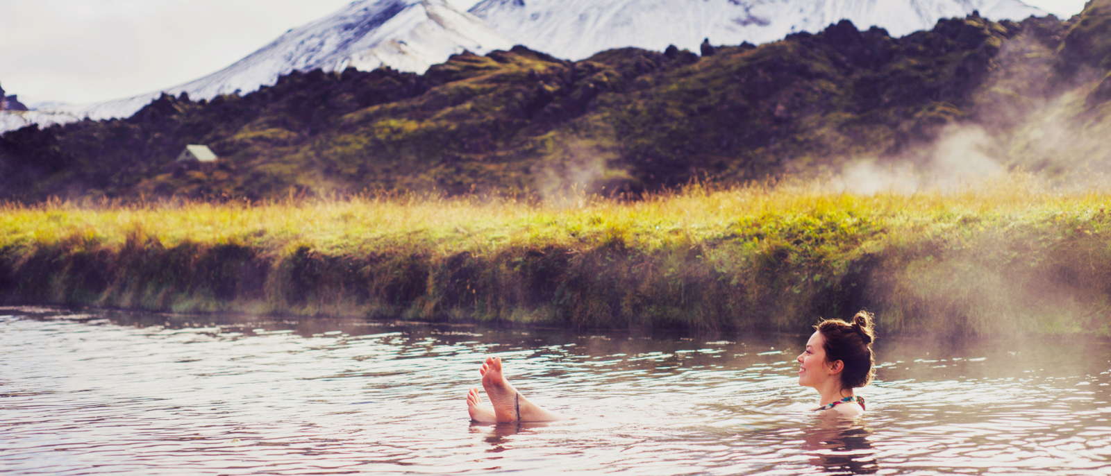 Girl in a hot spring in Iceland Landmannalaugar. Relaxing in a natural hot bath
