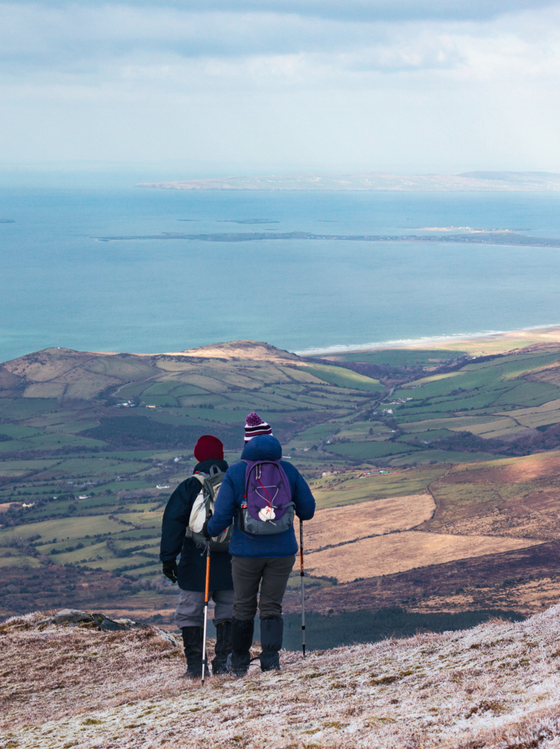 Walkers looking north from Slievanea mountain on the Dingle Peninsula towards the Maharees and Kerry Head in County Kerry, Ireland