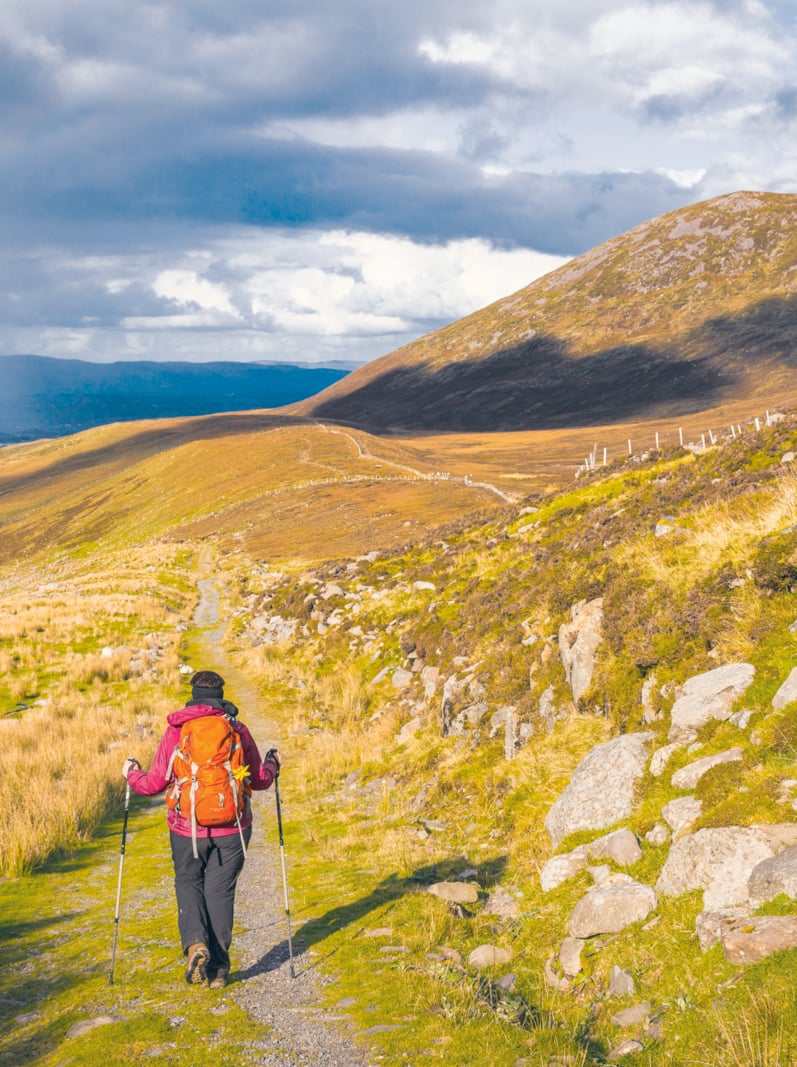 Randonnée pédestre dans les montagnes en Irlande avec pluie et arc-en-ciel au loin