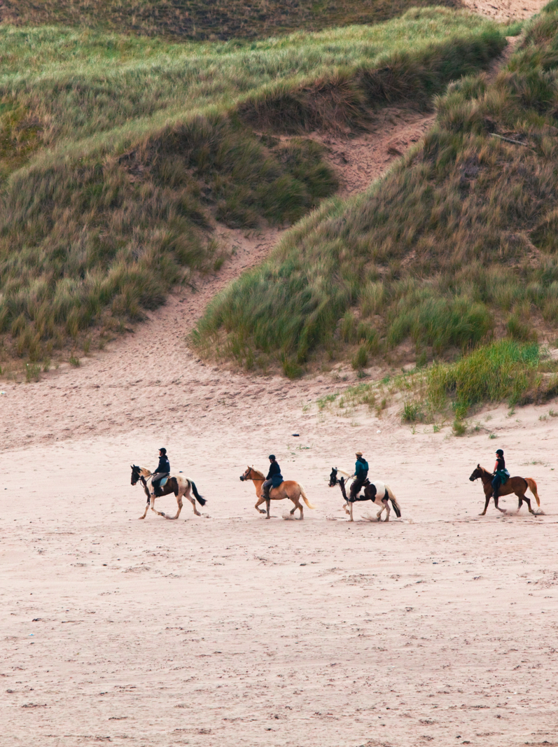 Four People Riding Horses On The Beach In County Donegal, Ireland