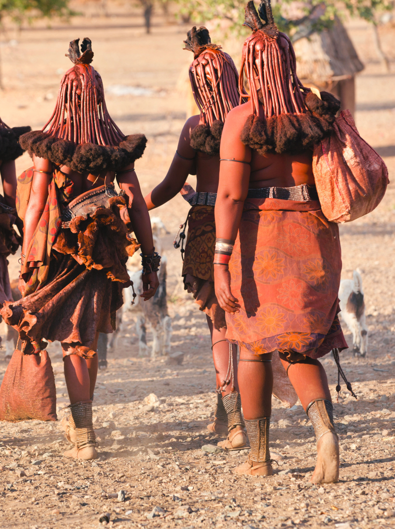 Les femmes himba retournent au village près de la ville d'Opuwo en Namibie
