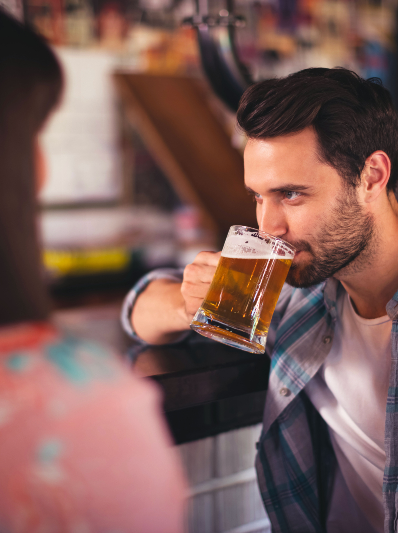 Couple having beer at counter in bar