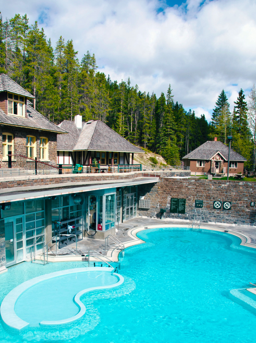 The buildings and pool of the Banff Upper Hot Springs. This famous tourist attraction has just opened on a early summer morning. The main pool in the photo is 39C. There is a smaller hotter pool out of the image