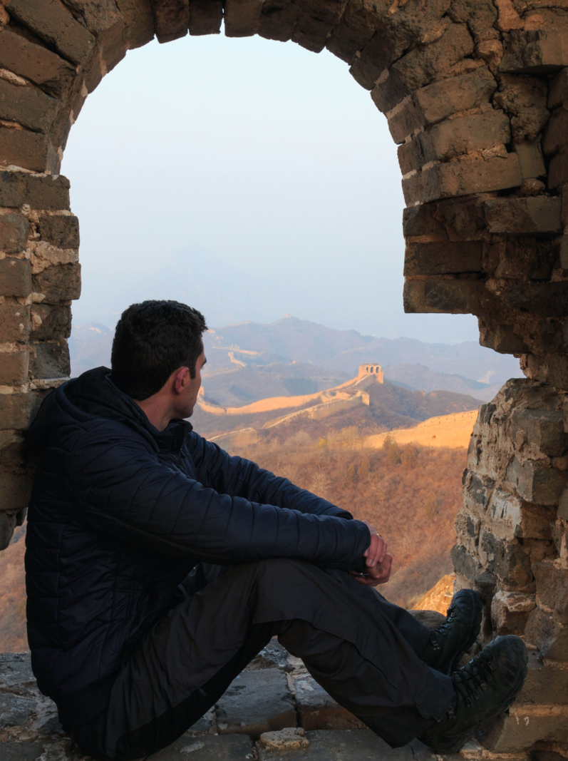Tourist at a tower of the Great Wall of China. The Great Wall of China is the world's longest wall and biggest ancient architecture
