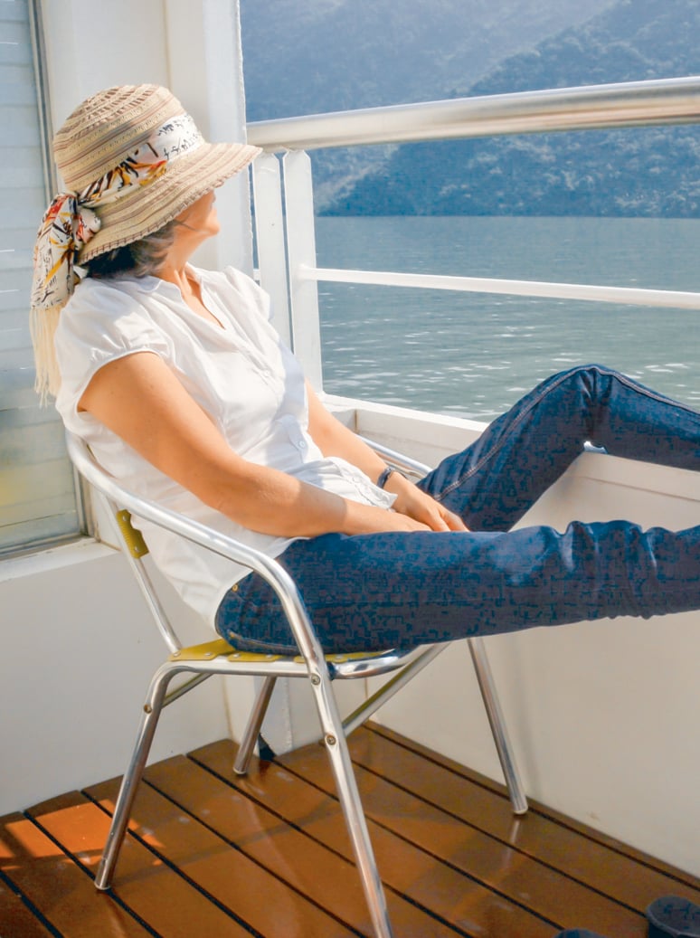 Woman with her feet up on railing of boat cruise, Yangtze river China