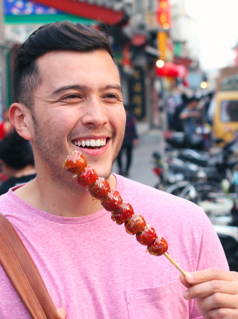 Man eating sugar-coated haws on a stick in China