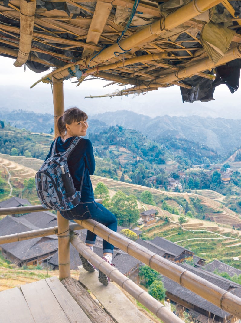traveling young woman with backpack on the background of rice terrace in China