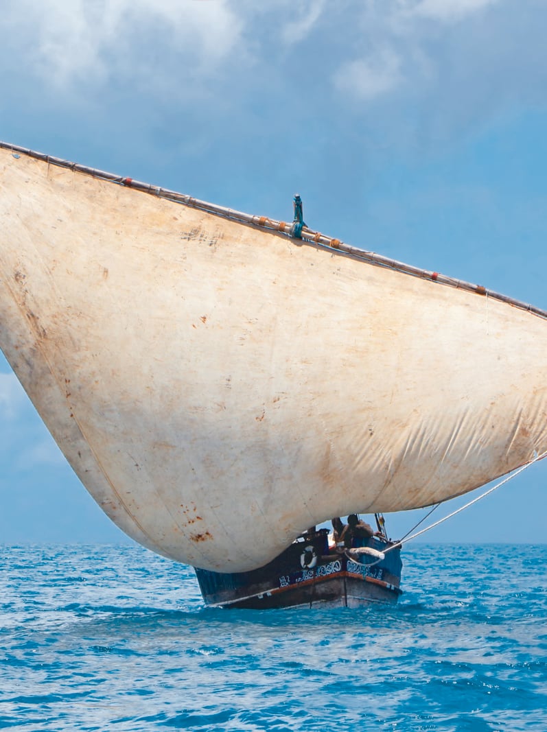 Wooden sailboat (dhow) on the open sea with clouds, Zanzibar