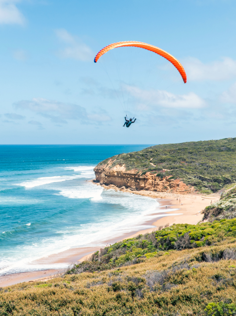 a man using a paraglider above the ocean