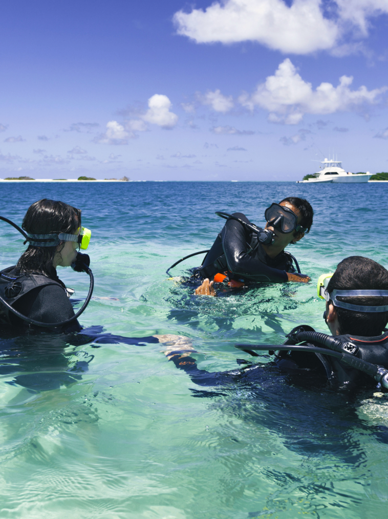 Maître de plongée formation un couple pour première plongée dans une plage de l’île tropicale de turquoise