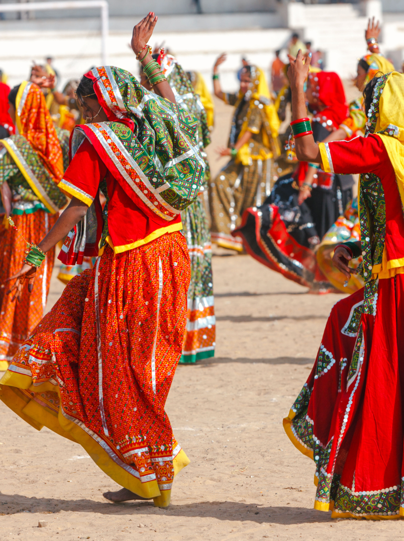 Indian girls in colorful ethnic attire dancing at Pushkar fair, Pushkar, Rajasthan, India, Asia