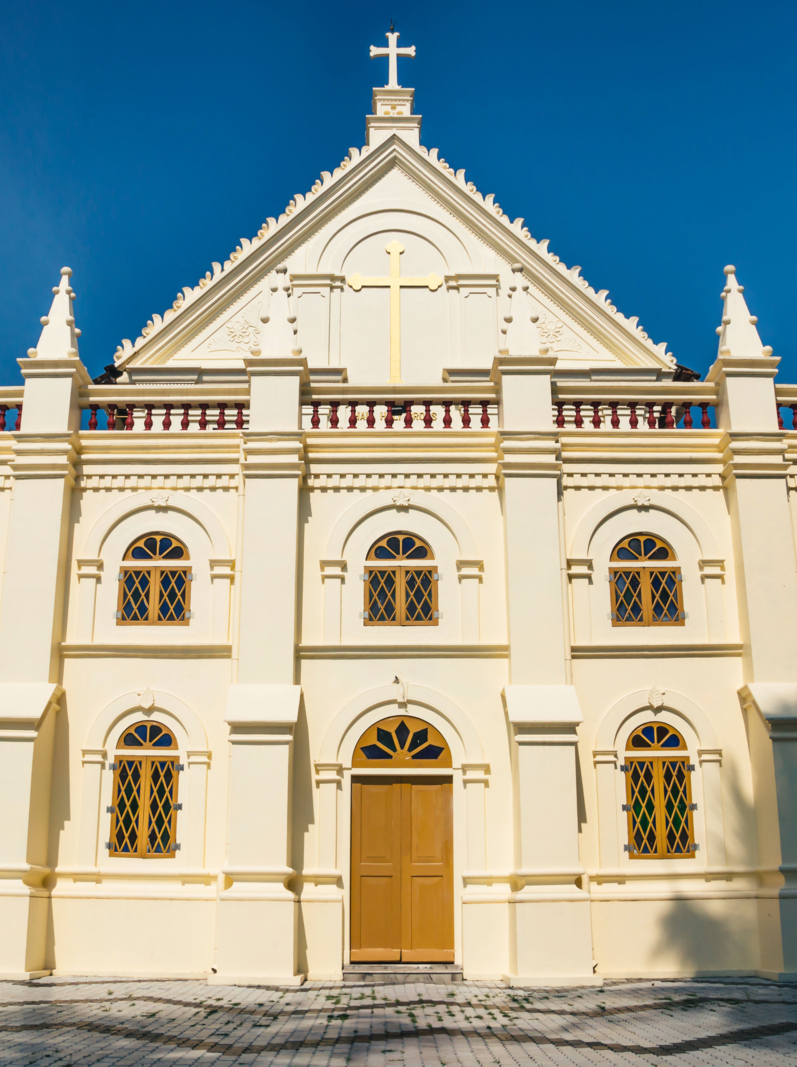 Front of Santa Cruz Cathedral Basilica white colonial church with blue cloudless sky in Kochi, Kerala, India