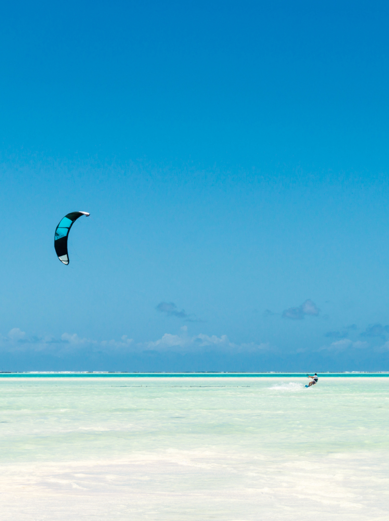 kitesurfing on tropical sea at low tide in Jambiani, Zanzibar, Tanzania Africa
