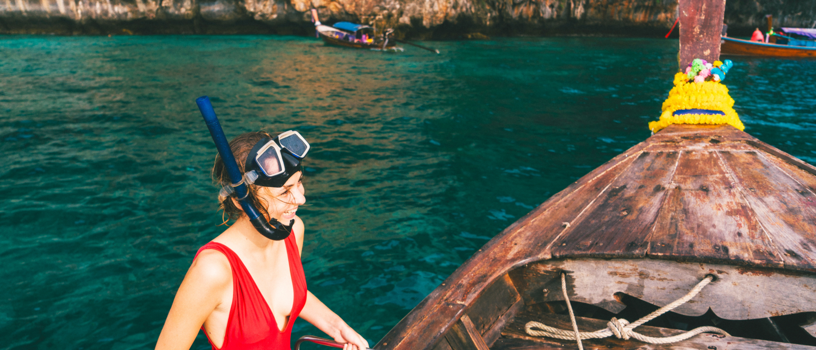 Young Caucasian woman in snorkeling mask in Thai Taxi boat in Krabi, Thailand